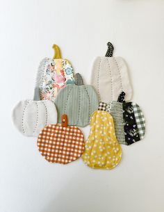 a group of pumpkins hanging on the side of a white wall with polka dots