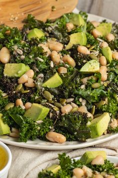 a white plate topped with broccoli, beans and avocado