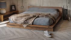 a bed sitting on top of a wooden platform next to a night stand and lamp