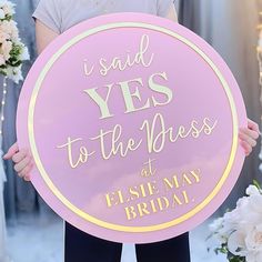 a woman holding a sign that says i said yes to the dress at elsie may bridal