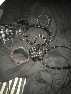 several different types of metal bracelets on a bed