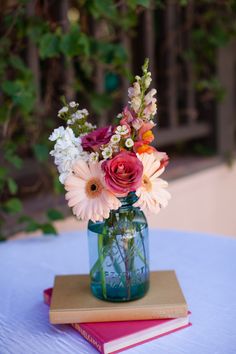 a vase filled with flowers sitting on top of a blue table cloth covered tablecloth