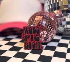 two shiny disco balls sitting on top of a checkered tablecloth with the words woop pig boogie