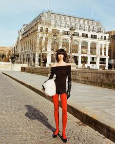 a woman in black dress and red tights