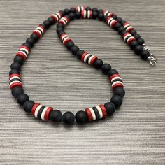 This necklace is made of 7mm round matte black onyx stone beads, 8mm red, white, and black ceramic rondelle beads. It has a stainless steel lobster claw style clasp and stainless steel wire guards. Available in lengths of 20-28 inches. Prices vary. Matching Bracelet: https://etsy.me/3WnMDKC Black Beaded Necklaces With Lobster Clasp, Modern Black Necklace With Round Beads, Modern Black Round Beads Necklace, Trinidad And Tobago Flag, Trinidad Tobago, Fredericksburg Va, Inspired Necklace, Black Onyx Stone, Matching Bracelet