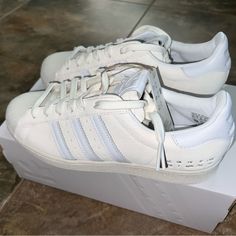 These Are The Best Of The Best Original Adidas Superstar In The Most Versatile Color Way Off-White And White! You Simply Cannot Go Wrong With These Absolute Classics. They Provide The Comfort Of Everyday Style And The Aesthetics Of The 90s To Today’s Vibe! Style Sports Season All Season Upper Material Two-Layer Suede Closure Lacing Sole Material Rubber Sole Toe Type Round Toe Heel Type Flat Heel Color Way White/Off-White Size M 7.5 / W 8.5 Brand New In Original Box Custom White Sneakers With Perforated Toe Box, Adidas White Sneakers With Perforated Toe Box, Adidas Original, Adidas Originals Superstar, Round Toe Heels, Best Of The Best, Heel Type, White Adidas, The 90s