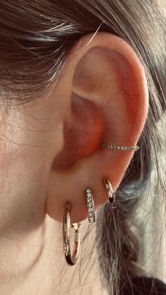 a close up of a person's ear with two small hoops attached to it