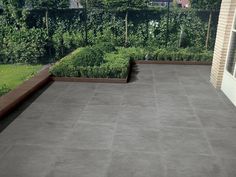 an outdoor patio with planters and trees in the background