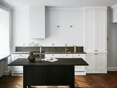 a kitchen with white cabinets and black counter tops is seen in this image from the front view