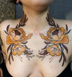 a woman with tattoos on her chest has flowers painted on her chest and is looking at the camera