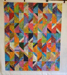 a colorful quilt hanging on a wall