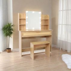 a wooden desk with a mirror on top of it and a plant in the corner