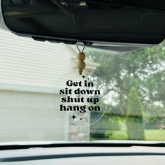 a car window with the words get in sit down shut up hang on it