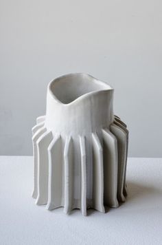 a white vase sitting on top of a table