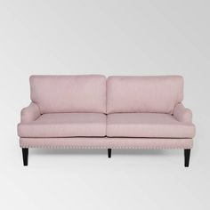 a pink couch sitting on top of a white floor