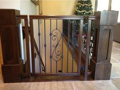 an open gate in the middle of a room with a christmas tree on the other side