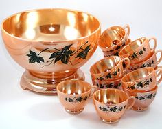 an assortment of gold colored dishes and cups