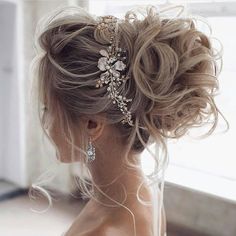 the back of a woman's head with long hair and flowers in her hair