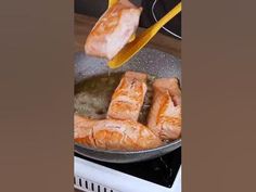 someone is cooking salmon in a pan on the stove