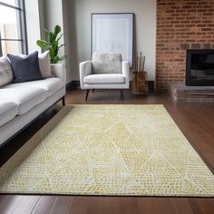 a living room with two white couches and a yellow rug on the hardwood floor