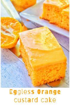 slices of orange cake with frosting on a white plate next to an orange slice