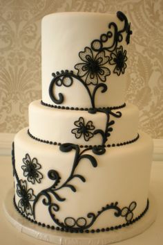 a three tiered white and black wedding cake