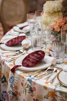 the table is set with white and gold place settings