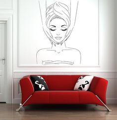 a line drawing of a woman's face on the wall above a red couch