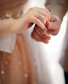 the bride and groom hold hands as they stand close to each other in their wedding dress