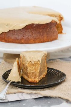 a piece of cake on a black plate with a knife and fork next to it