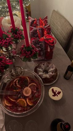 a table topped with plates and bowls filled with desserts next to candles on top of a table