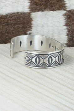 This sterling silver bracelet was made by Navajo silversmith Calvin Martinez. The inside is signed C MTZ, Navajo and stamped sterling.Size: 5 3/8" (will fit up to a 6 3/8" wrist)Gap: 1"Width: 5/8"Free shipping on all orders! We ship with USPS and always include tracking. All orders ship within a day of payment.Returns are accepted up to 30 days after you receive your order. Just send us a message. Our shop offers cash back or store credit. The item must be returned in new condition. Sterling Silver Inlay Bracelets In Silver Color, Southwestern Style Etched Sterling Silver Bracelet, Adjustable Etched Sterling Silver Southwestern Bracelet, Artisan Sterling Silver Bracelet With Inlay, Adjustable Etched Southwestern Sterling Silver Bracelet, Southwestern Sterling Silver Stamped Bangle Bracelet, Southwestern Style Stamped Sterling Silver Bangle Bracelet, Artisan Silver Bracelets With Inlay, Southwestern Style Stamped Sterling Silver Bangle