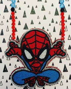 a spiderman beaded necklace on a white background