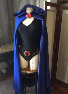 a mannequin wearing a blue cape with red buttons on it's chest