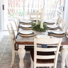 a dining room table set with white plates and place settings for six people to sit at