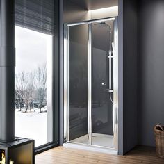 a bathroom with a glass shower stall and wood flooring next to a large window