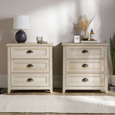 two wooden dressers sitting next to each other on a rug in front of a wall