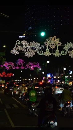 people are riding motorcycles down the street at night with decorations on it's sides