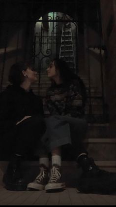 two people are sitting on the steps and one is kissing another person's nose