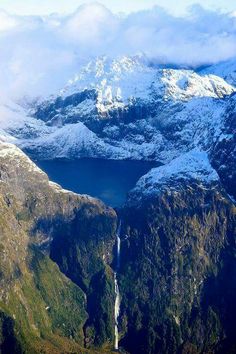 the mountains are covered in snow and water as seen from an aerial view point on a sunny day