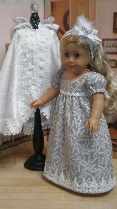 a doll standing next to a dress on a mannequin