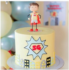 a birthday cake with a super hero figure on top