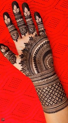 the hand is decorated with henna designs on red background stock photo - 1307982