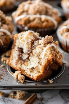 muffins with white icing and cinnamon crumbs on a baking tray