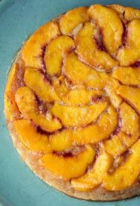 a pastry with bananas on it sitting on top of a blue plate next to a fork