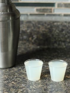 two shot glasses sitting on top of a counter