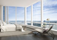 a bedroom with large windows and a view of the city from it's floor to ceiling windows