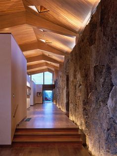 a long hallway with stone walls and wooden ceiling