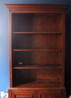 a wooden bookcase with two doors and drawers