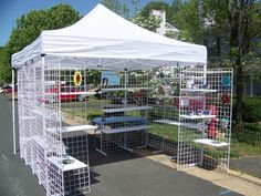 several cages are set up in front of a white tent